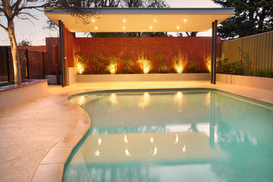 Inspiration for a large traditional backyard pool in Perth with brick pavers.
