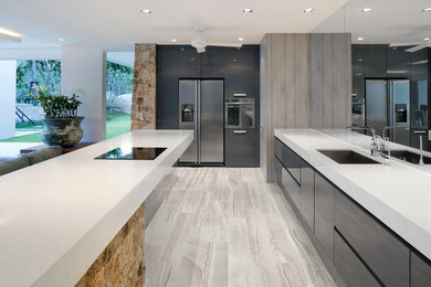 Large contemporary galley eat-in kitchen in Melbourne with an undermount sink, flat-panel cabinets, medium wood cabinets, mirror splashback, stainless steel appliances and porcelain floors.