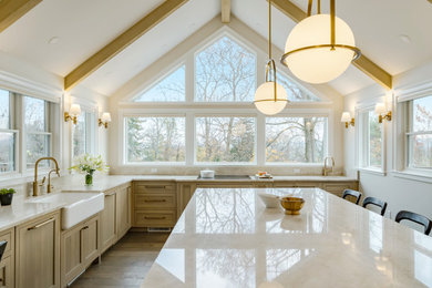 Eat-in kitchen - large transitional l-shaped laminate floor, brown floor and exposed beam eat-in kitchen idea in Philadelphia with a farmhouse sink, beaded inset cabinets, light wood cabinets, granite countertops, beige backsplash, granite backsplash, paneled appliances, an island and beige countertops