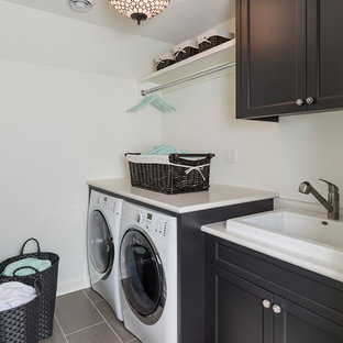Photo of a medium sized classic single-wall separated utility room in Minneapolis with a built-in sink, black cabinets, laminate countertops, white walls, porcelain flooring, a side by side washer and dryer and shaker cabinets.