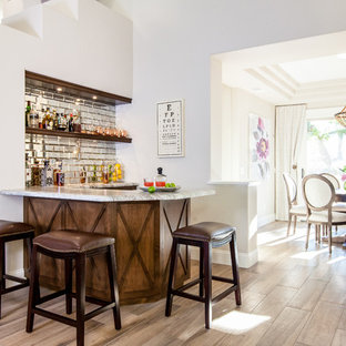 サンディエゴの地中海スタイルのおしゃれな着席型バー (オープンシェルフ、濃色木目調キャビネット、ミラータイルのキッチンパネル、淡色無垢フローリング) の写真