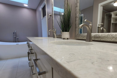 Example of a large arts and crafts master brown tile and porcelain tile porcelain tile, beige floor and double-sink bathroom design in Seattle with shaker cabinets, white cabinets, a one-piece toilet, beige walls, an undermount sink, quartz countertops, a hinged shower door, beige countertops and a built-in vanity