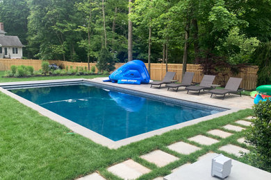 Large trendy backyard tile and rectangular pool landscaping photo in New York