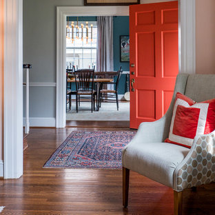 Inredning av en eklektisk mellanstor ingång och ytterdörr, med grå väggar, mellanmörkt trägolv, en orange dörr och brunt golv