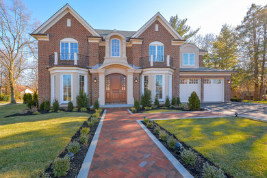 Inspiration for a mid-sized transitional red two-story brick house exterior remodel in New York with a shingle roof