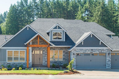 This is an example of a large arts and crafts two-storey grey house exterior in Portland with concrete fiberboard siding, a clipped gable roof and a shingle roof.