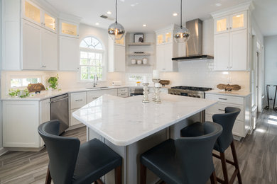 Mid-sized modern l-shaped eat-in kitchen in Atlanta with an undermount sink, recessed-panel cabinets, white cabinets, white splashback, stainless steel appliances, porcelain floors, with island, grey floor, white benchtop, marble benchtops and subway tile splashback.