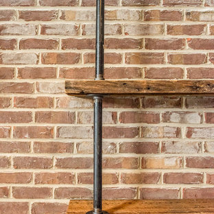 Modelo de sótano con ventanas rústico, grande, sin chimenea, con paredes grises, suelo de madera en tonos medios y suelo marrón