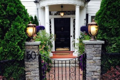 Small elegant brick porch photo in Boston with a roof extension