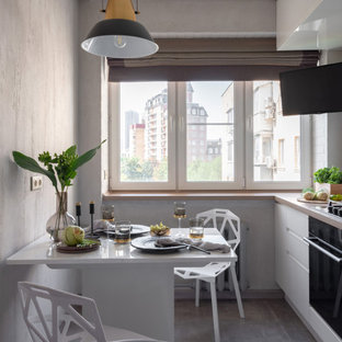 Удачное сочетание для дизайна помещения: маленькая угловая кухня в современном стиле с плоскими фасадами, белыми фасадами, черной техникой, серым полом, обеденным столом и бежевой столешницей без острова - самое интересное для вас