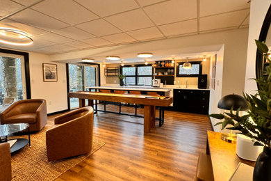Basement game room - large modern vinyl floor, brown floor and wallpaper basement game room idea in Other