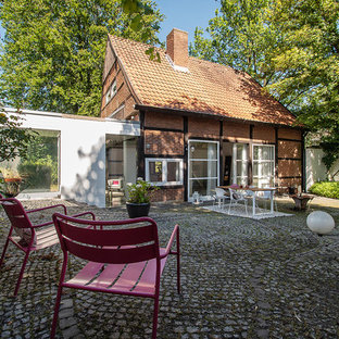 Mittelgroßes, Zweistöckiges, Rotes Landhausstil Einfamilienhaus mit Backsteinfassade, Satteldach und Ziegeldach in Sonstige