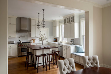 Traditional kitchen in Boston with white cabinets, medium hardwood floors and with island.