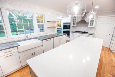 Example of a transitional kitchen design in Detroit with shaker cabinets and an island