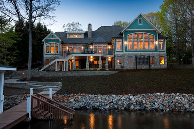 Example of a large transitional blue three-story concrete fiberboard exterior home design in Other with a hip roof
