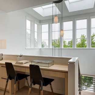 Inspiration for a small modern home office and library in Minneapolis with white walls, light hardwood flooring and a built-in desk.