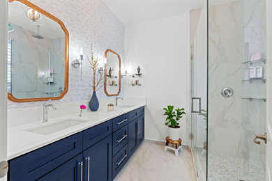 Corner shower - mid-sized transitional master double-sink and wallpaper corner shower idea in Miami with shaker cabinets, blue cabinets, quartz countertops, a hinged shower door, white countertops and a built-in vanity