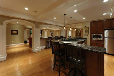 Open concept kitchen - large traditional light wood floor and beige floor open concept kitchen idea in Chicago with raised-panel cabinets, medium tone wood cabinets, granite countertops, stainless steel appliances and an island
