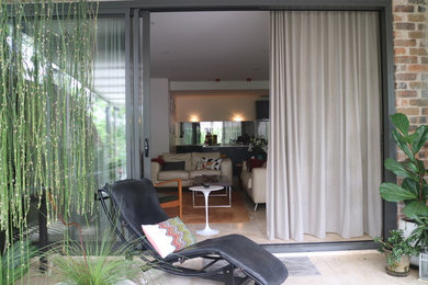 Photo of a mid-sized contemporary living room in Sydney with white walls and travertine floors.