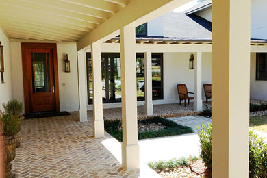 Inspiration for a mid-sized contemporary front yard brick patio remodel in Miami with a roof extension