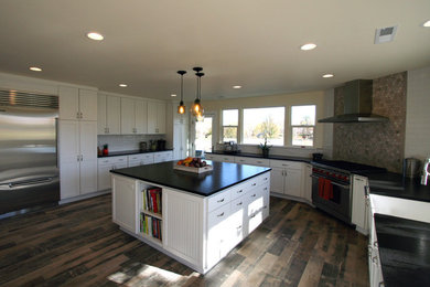 Inspiration for a large cottage u-shaped ceramic tile open concept kitchen remodel in Other with a farmhouse sink, shaker cabinets, white cabinets, granite countertops, beige backsplash, stone tile backsplash, stainless steel appliances and an island
