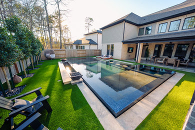Pool - large modern backyard rectangular pool idea in Houston with a bbq area and decking