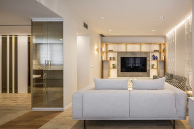Diseño de salón tipo loft y blanco y madera pequeño con paredes beige, suelo de madera clara, televisor colgado en la pared y suelo marrón