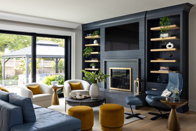 Inspiration for a mid-sized transitional light wood floor and beige floor living room remodel in New York with gray walls, a standard fireplace, a stone fireplace and a media wall