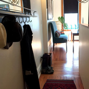 Idéer för en liten eklektisk hall, med vita väggar, mellanmörkt trägolv, en enkeldörr, metalldörr och brunt golv