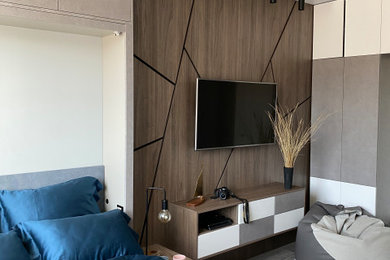 На фото: серо-белая спальня в современном стиле с полом из ламината, панелями на стенах и акцентной стеной