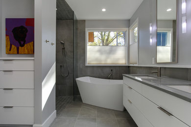 Small contemporary master bathroom in Raleigh with flat-panel cabinets, white cabinets, a freestanding tub, an open shower, a one-piece toilet, gray tile, porcelain tile, grey walls, porcelain floors, an undermount sink and engineered quartz benchtops.