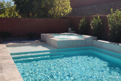 Example of a mid-sized minimalist backyard stone and rectangular pool design in Las Vegas
