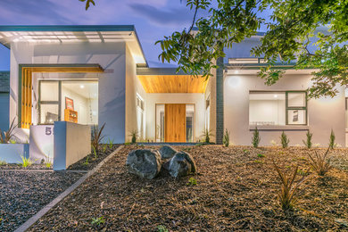 Inspiration for a large modern two-storey brick white house exterior in Canberra - Queanbeyan with a flat roof and a metal roof.