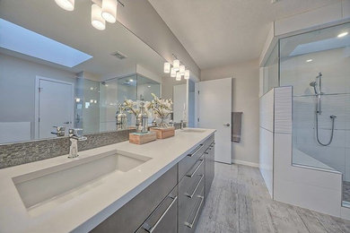 Example of a large trendy master gray floor bathroom design in Calgary with gray walls, an undermount sink, quartz countertops, flat-panel cabinets, gray cabinets and a hinged shower door