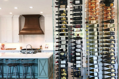 Example of a small trendy light wood floor and brown floor wine cellar design in Other with display racks
