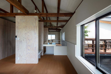 Kleine, Offene Bibliothek ohne Kamin mit weißer Wandfarbe, Sperrholzboden, freistehendem TV, braunem Boden, freigelegten Dachbalken und Tapetenwänden in Kobe