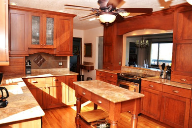 Example of a mid-sized classic u-shaped medium tone wood floor eat-in kitchen design in Denver with an undermount sink, beaded inset cabinets, medium tone wood cabinets, granite countertops, brown backsplash, porcelain backsplash, stainless steel appliances and an island