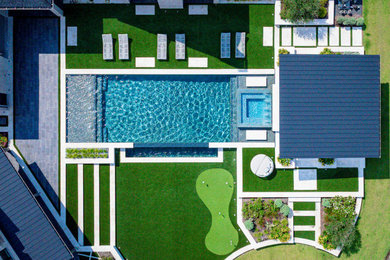 Inspiration for a large backyard stone and rectangular infinity hot tub remodel in Houston