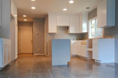 Photo of a large transitional galley eat-in kitchen in Detroit with shaker cabinets, white cabinets, porcelain floors, with island and beige floor.