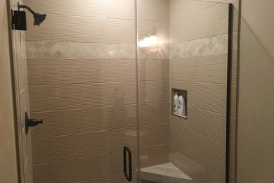 Inspiration for a mid-sized contemporary 3/4 beige tile and porcelain tile porcelain tile and beige floor alcove shower remodel in Milwaukee with recessed-panel cabinets, black cabinets, a one-piece toilet, beige walls, an undermount sink, granite countertops, a hinged shower door and black countertops