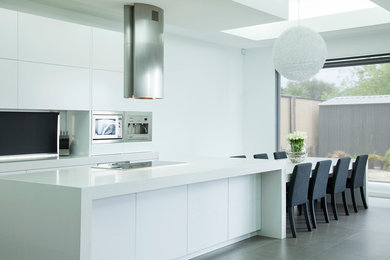 Design ideas for a large modern l-shaped eat-in kitchen in Sydney with stainless steel appliances, with island, an undermount sink, flat-panel cabinets, white cabinets, quartz benchtops and porcelain floors.
