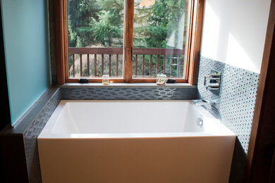 Inspiration for a large modern master glass tile porcelain tile bathroom remodel in Portland with an undermount sink, dark wood cabinets and solid surface countertops