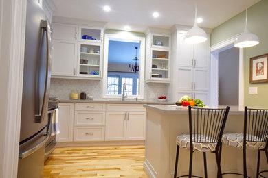 Example of a mid-sized trendy l-shaped light wood floor enclosed kitchen design in Toronto with an undermount sink, shaker cabinets, white cabinets, gray backsplash, stainless steel appliances, quartzite countertops, a peninsula and marble backsplash