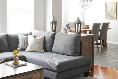 Family room - mid-sized rustic open concept medium tone wood floor family room idea in Vancouver with a standard fireplace, a stone fireplace, a wall-mounted tv and white walls