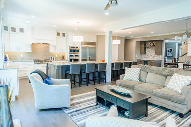 Large transitional l-shaped light wood floor and gray floor open concept kitchen photo in St Louis with an undermount sink, shaker cabinets, white cabinets, quartz countertops, gray backsplash, ceramic backsplash, stainless steel appliances, an island and multicolored countertops