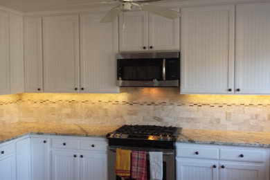 Small elegant u-shaped enclosed kitchen photo in Richmond with a double-bowl sink, white cabinets, brown backsplash, ceramic backsplash, stainless steel appliances, a peninsula, recessed-panel cabinets and granite countertops