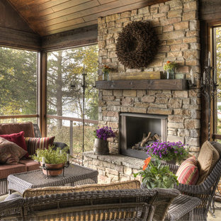 Ejemplo de porche cerrado rústico, grande, en anexo de casas y patio trasero