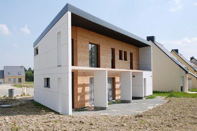 Cette image montre une façade de maison blanche design en bois de taille moyenne et à deux étages et plus avec un toit plat et un toit en métal.