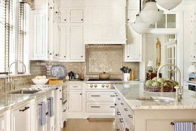 Mid-sized elegant l-shaped light wood floor open concept kitchen photo in Atlanta with an undermount sink, white cabinets, beige backsplash, an island, beaded inset cabinets, granite countertops, porcelain backsplash and paneled appliances