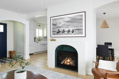 Mid-sized french country enclosed light wood floor and yellow floor living room photo in Toronto with beige walls, a standard fireplace, a stone fireplace and a wall-mounted tv